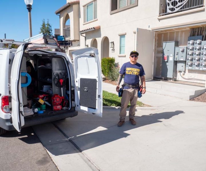 An electrician steps out from his fully equipped service van, showcasing readiness for a wide range of electrical installation and repair tasks.