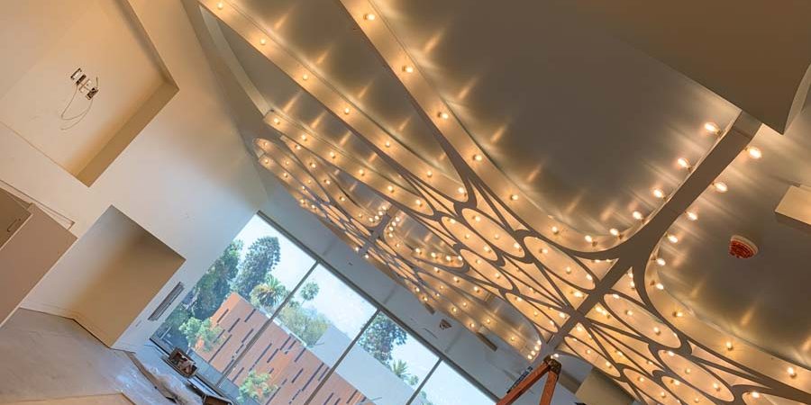 A spacious interior of a commercial building displaying a modern lighting installation with curving designs and soft illumination.